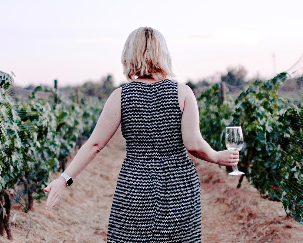A lady at a vineyard holding a glass of wine